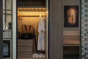 A hotel room with a wooden wardrobe, a hanging coat rack, a suitcase, and a pair of slippers on the floor. - Radisson Blu Resort, Phuket Mai Khao Beach (Mai Khao)