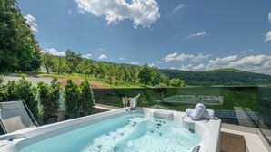 Ein Whirlpool mit Blick auf einen See und Hügel.