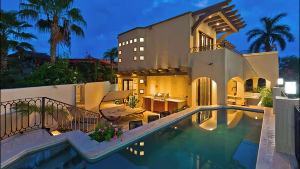 A modern building with a pool, outdoor seating, and a covered patio area. - Marbella Lane - PrimeVilla n Modern Home (Cabo San Lucas)