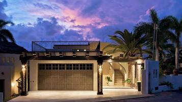 A modern house with a garage, a covered patio, and a staircase leading to a second floor.