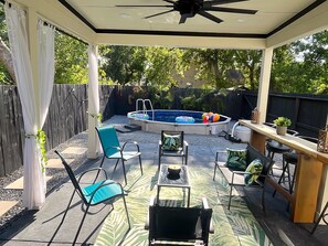 A covered patio area with a pool, seating, and a bar. - Peaceful 3-bedroom House with Pool in Houston neighborhood (Houston)