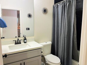 A bathroom with a white sink, a toilet, and a shower curtain. - Peaceful 3-bedroom House with Pool in Houston neighborhood (Houston)