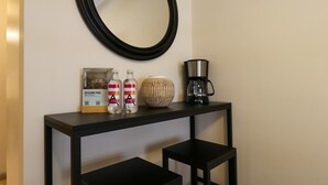 A black console table with a framed picture, two bottles, a striped vase, and a coffee maker. - w Amazing Loft w Balcony in Miraflores (Lima)