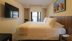 A hotel room with a large bed, a flat-screen TV mounted on the wall, a painting above the bed, and a view of the outside through a door. - w Amazing Loft w Balcony in Miraflores (Lima)