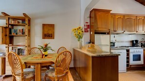 Una cucina con mobili in legno, un tavolo da pranzo con sedie e un'isola piccola.