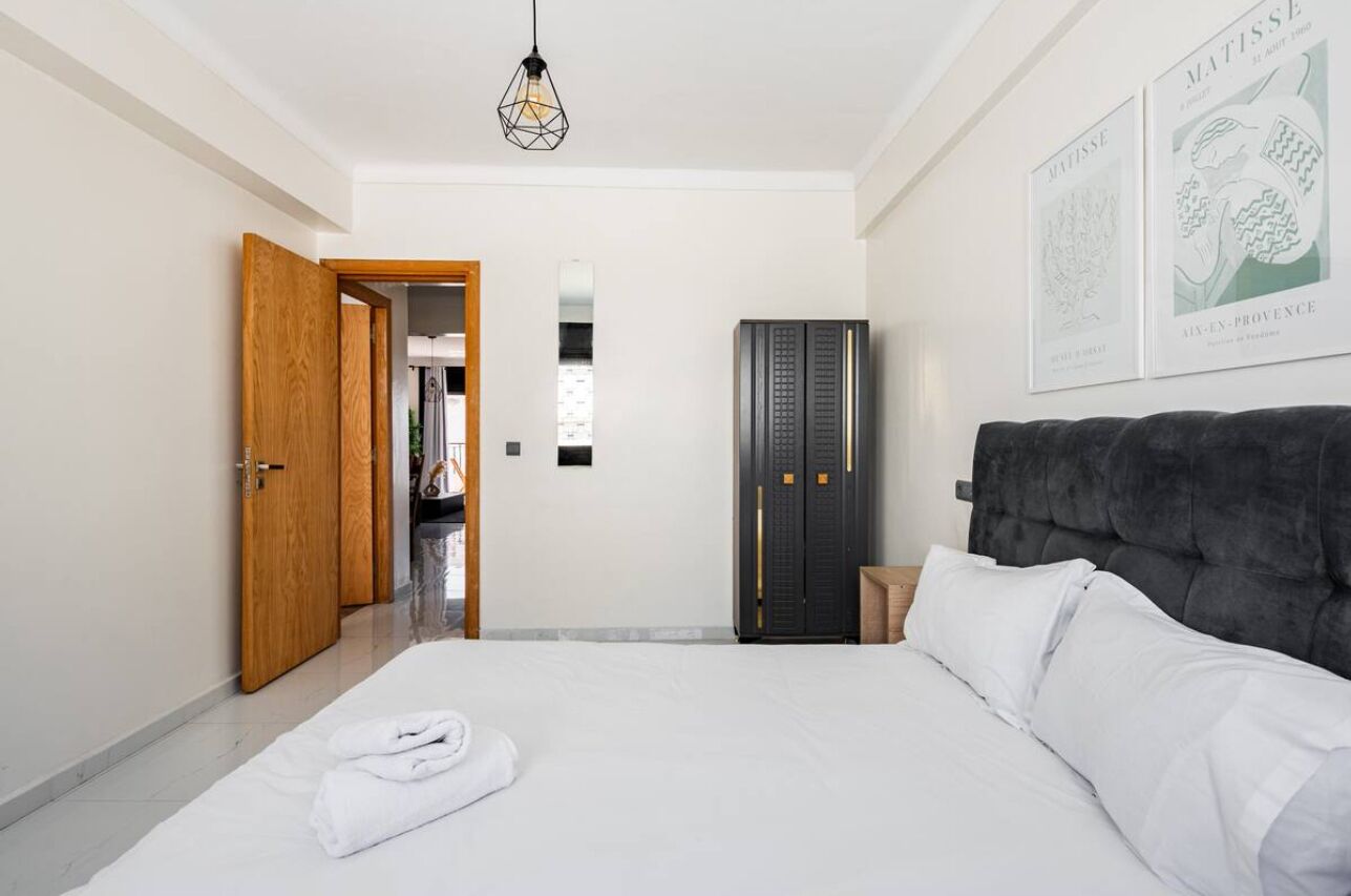 Ein Schlafzimmer mit Bett, Schrank und einer Tür zum Badezimmer.