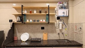 A modern kitchen with a granite countertop, built-in shelves, and a sink. - Aesthetic 1bhk luxe Indore (Indore)
