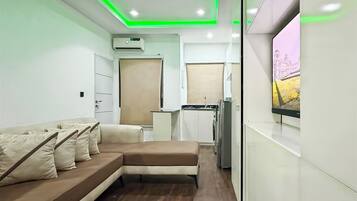 Habitación junior, balcón, vista a la ciudad | Área de sala de estar