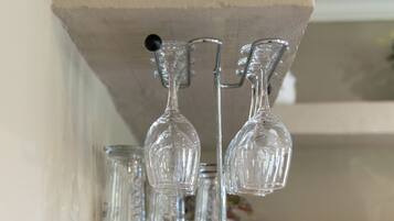 A kitchen shelf with glassware and a small plant.
