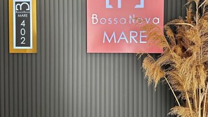 A wall with a vertical striped pattern, a framed sign with the number 402, and a pink sign with the text "BossaNova MARE". - Bossa Nova Mare (Kas)