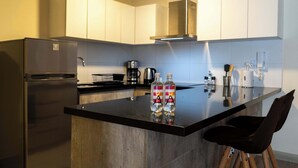 A modern kitchen with a stainless steel refrigerator, a coffee maker, and a black countertop. - w Comfortable 2BR w Balcony in Miraflores (Lima)