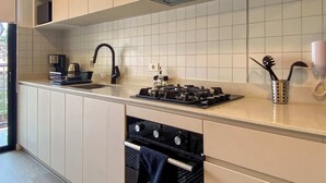A modern kitchen with a built-in stove, a sink, and a microwave. - w Enchanting Loft w Balcony in Barranco (Lima)
