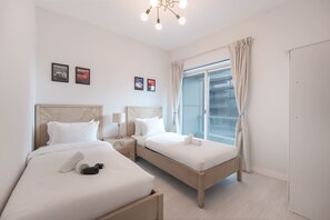 A hotel room with two beds, a large window with curtains, and framed pictures on the wall. - A Free Housekeeping Visit FOR Every Stay Between THE 16th FEB AND THE 16th MAR - Stayshort - Stlylish 2 Bedroom in Dubai Marina That Sleeps 4 Near Met (Dubai)
