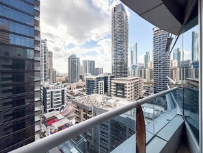 Ein Hochhaus mit moderner Glasfassade, umgeben von weiteren hohen Gebäuden, was auf eine dichte städtische Umgebung hindeutet.