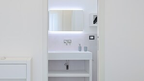 A modern bathroom with a white sink, mirror, and shelves. - Independent Villa with Pool, Sea View, Wi-Fi, and Air Conditioning (Ugento)