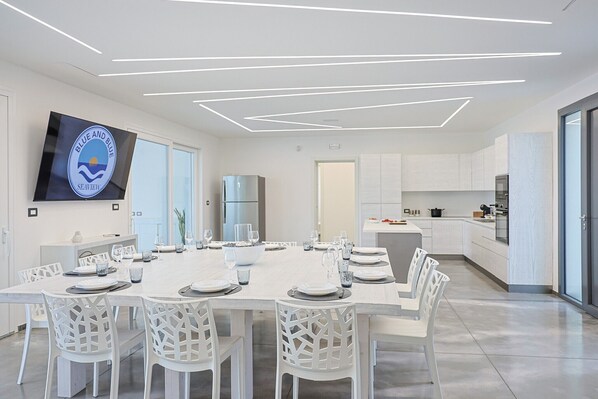 A modern kitchen with white cabinetry, a built-in oven, and a large island with a sink.