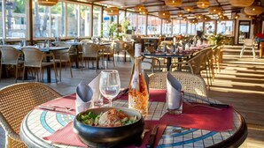 A restaurant with round tables, wicker chairs, and hanging pendant lights. - Chalet Prestige - Oasis Village 5 stars - Comfort and calm (Puget-sur-Argents)
