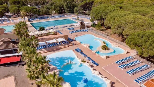 A resort with multiple swimming pools, lounge areas, and a mountainous backdrop. - Chalet Prestige - Oasis Village 5 stars - Comfort and calm (Puget-sur-Argents)