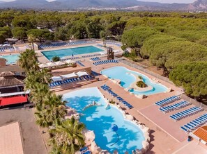 A resort with multiple swimming pools, lounge areas, and a mountainous backdrop. - Chalet Prestige - Oasis Village 5-Star - Comfort and Tranquility (Puget-sur-Argents)