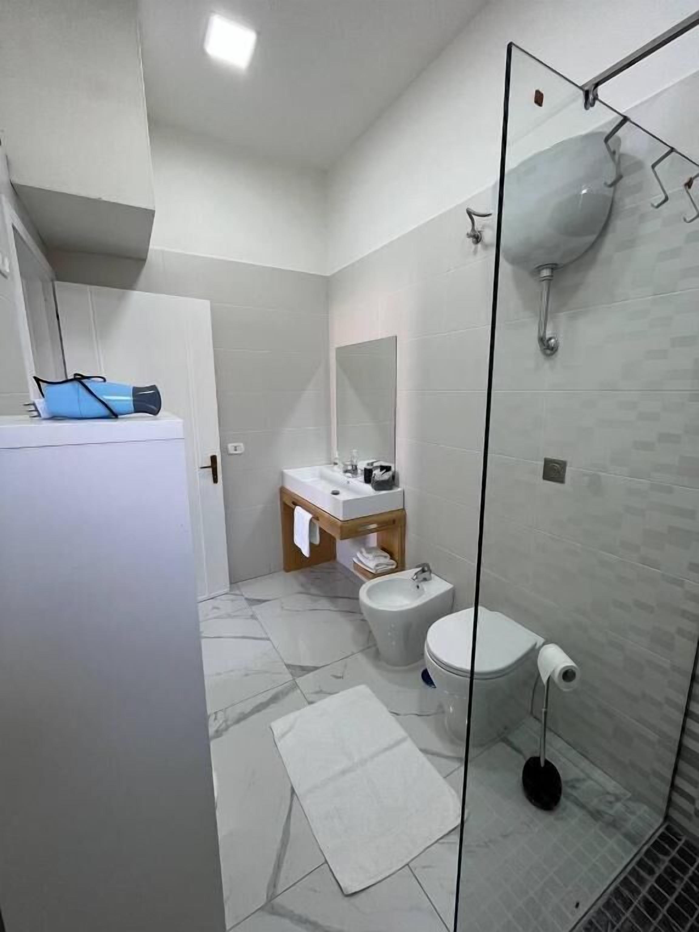 Uma casa de banho moderna com sanita, bidé e cabine de duche em vidro.