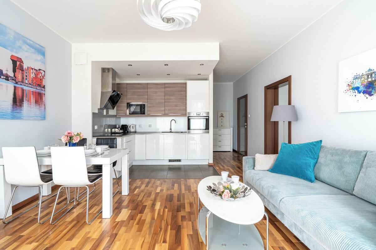 Um apartamento moderno com área de jantar, cozinha e sala de estar.