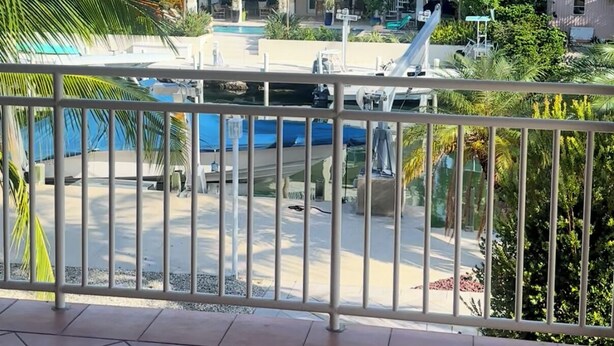 Un hotel con piscina, palme e vista sull'edificio.