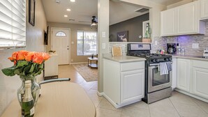 A modern kitchen with white cabinetry, a stainless steel oven, and a countertop with a coffee maker. - 4 Mi to Dtwn Phx: Midtown Condo w/ Patio! (Phoenix)