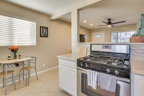 Une cuisine équipée d’une cuisinière à gaz, d’un four et d’un coin repas avec des chaises et une table.