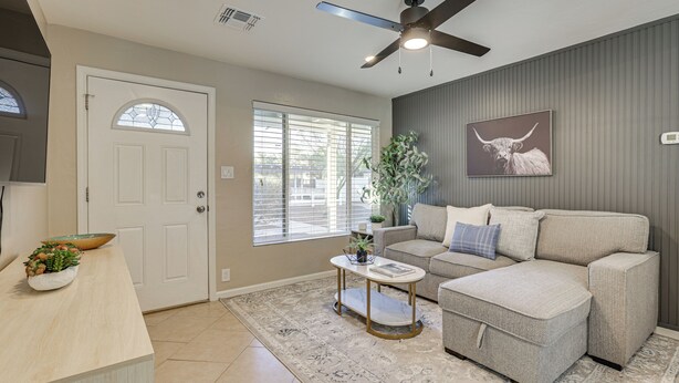 A living room with a ceiling fan, a sofa, a coffee table, and a door with a window. - 4 Mi to Dtwn Phx: Midtown Condo w/ Patio! (Phoenix)