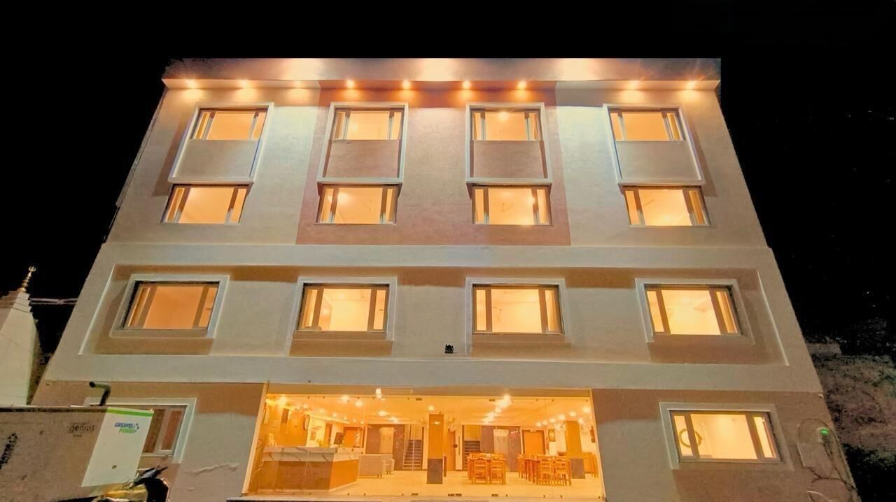 A multi-story hotel with illuminated windows and a visible ground floor restaurant area.