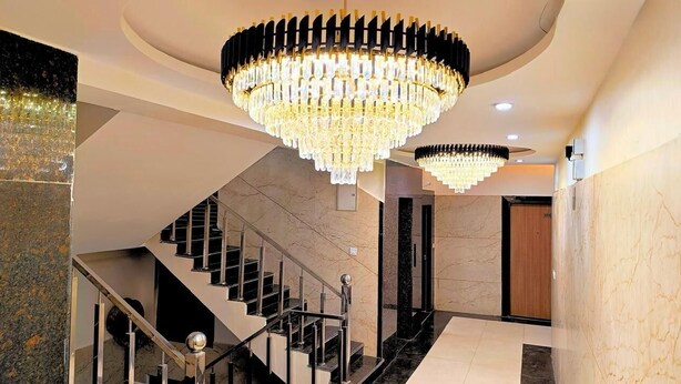 Eine prachtvolle Treppe mit einem Kronleuchter, Marmorwänden und modernem Interieur.