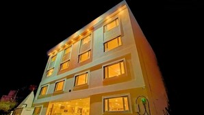 Ein mehrstöckiges Hotelgebäude mit beleuchteten Fenstern und einem gut sichtbaren Eingang.