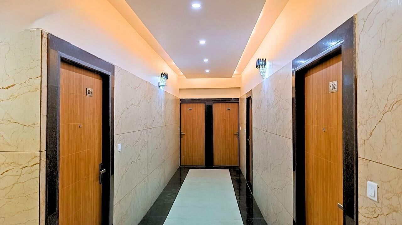 A corridor with marble walls and wooden doors, each marked with a number.