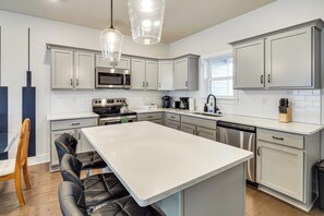A modern kitchen with white cabinets, stainless steel appliances, and a central island with seating. - 6 Mi to Broadway: Nashville Townhome w/ Balcony! (Nashville)