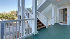 A covered porch with a staircase leading to a second floor, a door labeled "EXIT," and a sign reading "BEACH HOUSE." - < 5 Mi to Private Beach Access! Myrtle Beach Condo (Myrtle Beach)