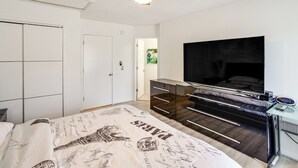Une chambre à coucher comprenant un lit, une armoire, un bureau et un ventilateur de plafond.