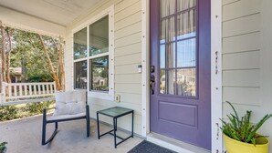 A porch with a bench, a small table, a purple door, and a potted plant. - < 2 Mi to Dtwn! Quiet Family Home in Pensacola (Pensacola)
