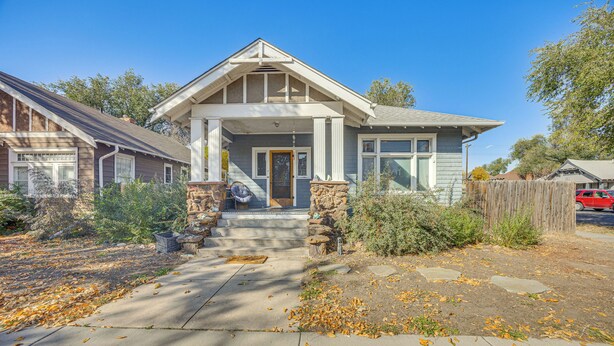 A two-story house with a front porch, stone pillars, and a front yard with fallen leaves. - Walk to Colorado College & Dwtn! Home w/ Patio (Colorado Springs)