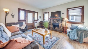 A living room with a fireplace, a sofa, a coffee table, and a television. - Walk to Colorado College & Dwtn! Home w/ Patio (Colorado Springs)