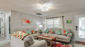 A living room with a sofa, coffee table, and decorative pillows. - Golf, Dine & Relax Poolside! The Villages Retreat (The Villages)
