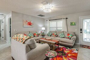 Un salon avec un canapé, une table basse et des coussins décoratifs.
