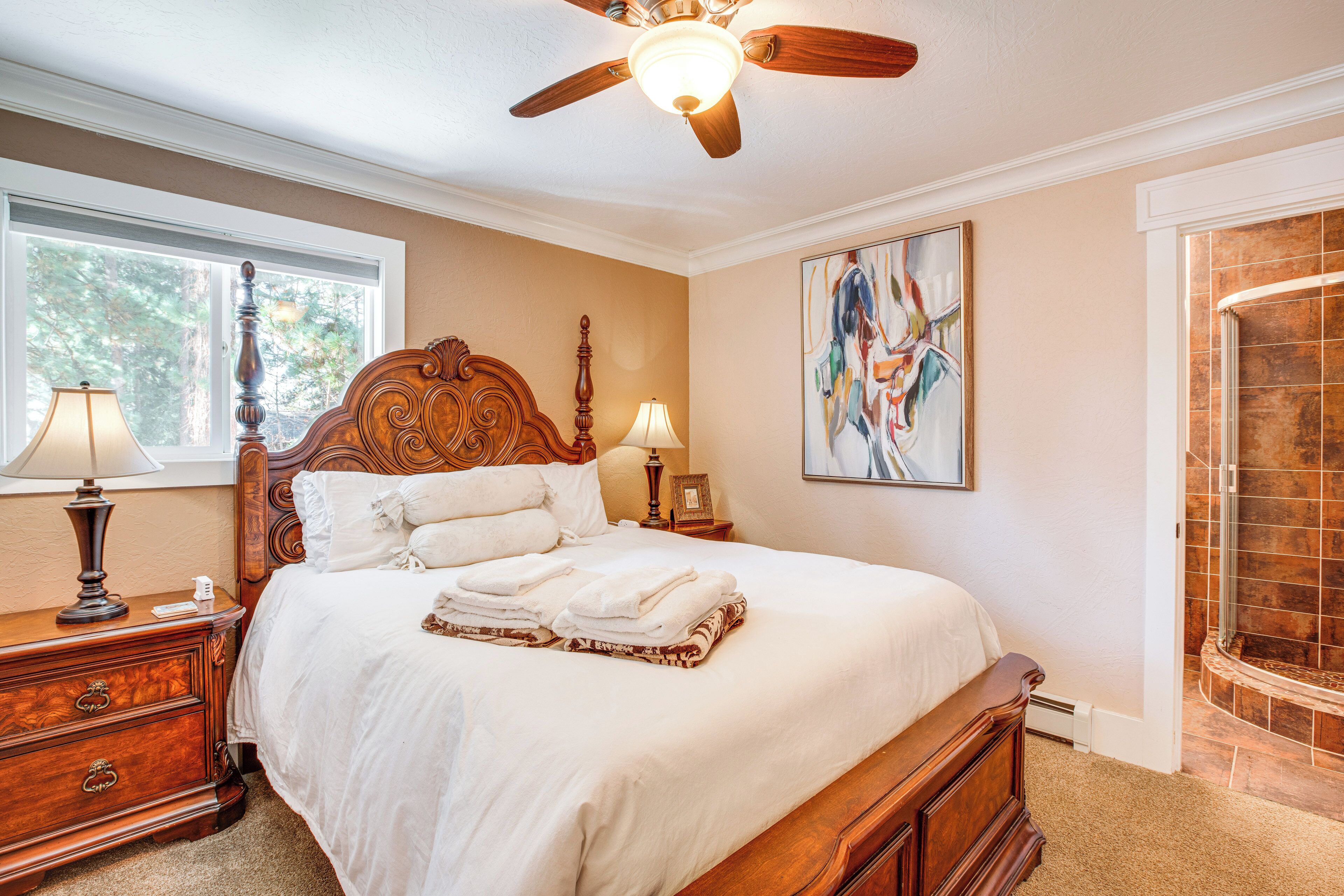 A neatly made bed with white linens, a wooden headboard, and a bedside table with a lamp.