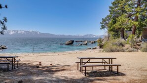 Une plage avec une table de pique-nique et une vue sur la montagne.