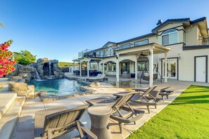 A large house with a swimming pool, outdoor furniture, and a waterfall feature. - Expansive Riverside Mansion! Luxe, Family Friendly (Riverside)