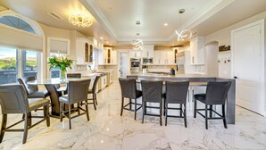A spacious kitchen with a large island, modern appliances, and a dining area with bar stools.