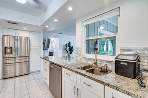 A modern kitchen with stainless steel appliances, a granite countertop, and a window providing natural light. - Location, Location, Location! Direct Gulf Access (Port Charlotte)