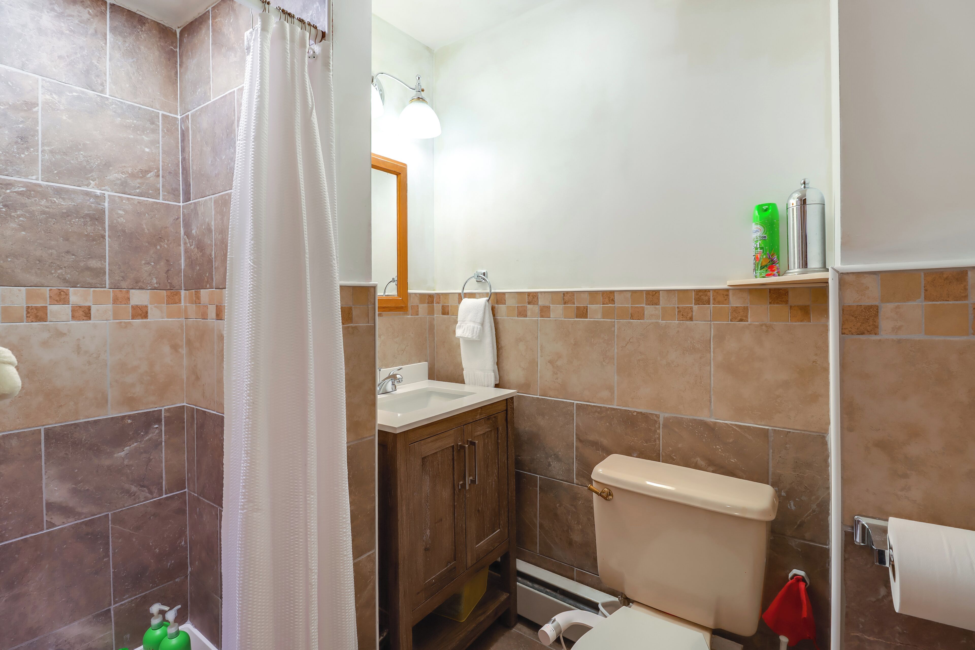 Une salle de bain équipée d’une douche, d’un lavabo, de toilettes et d’un miroir.