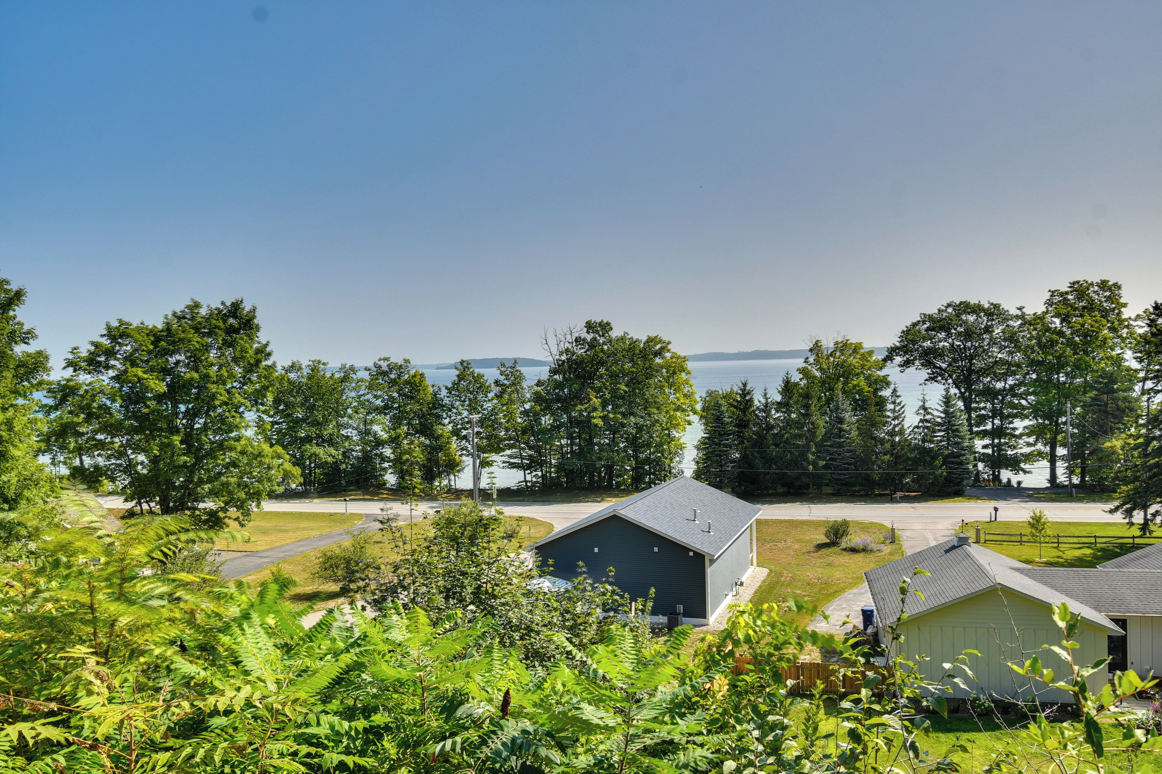 A residential area with houses, a road, and a body of water in the background.