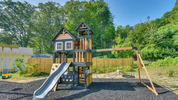 A playground with a slide and swings.