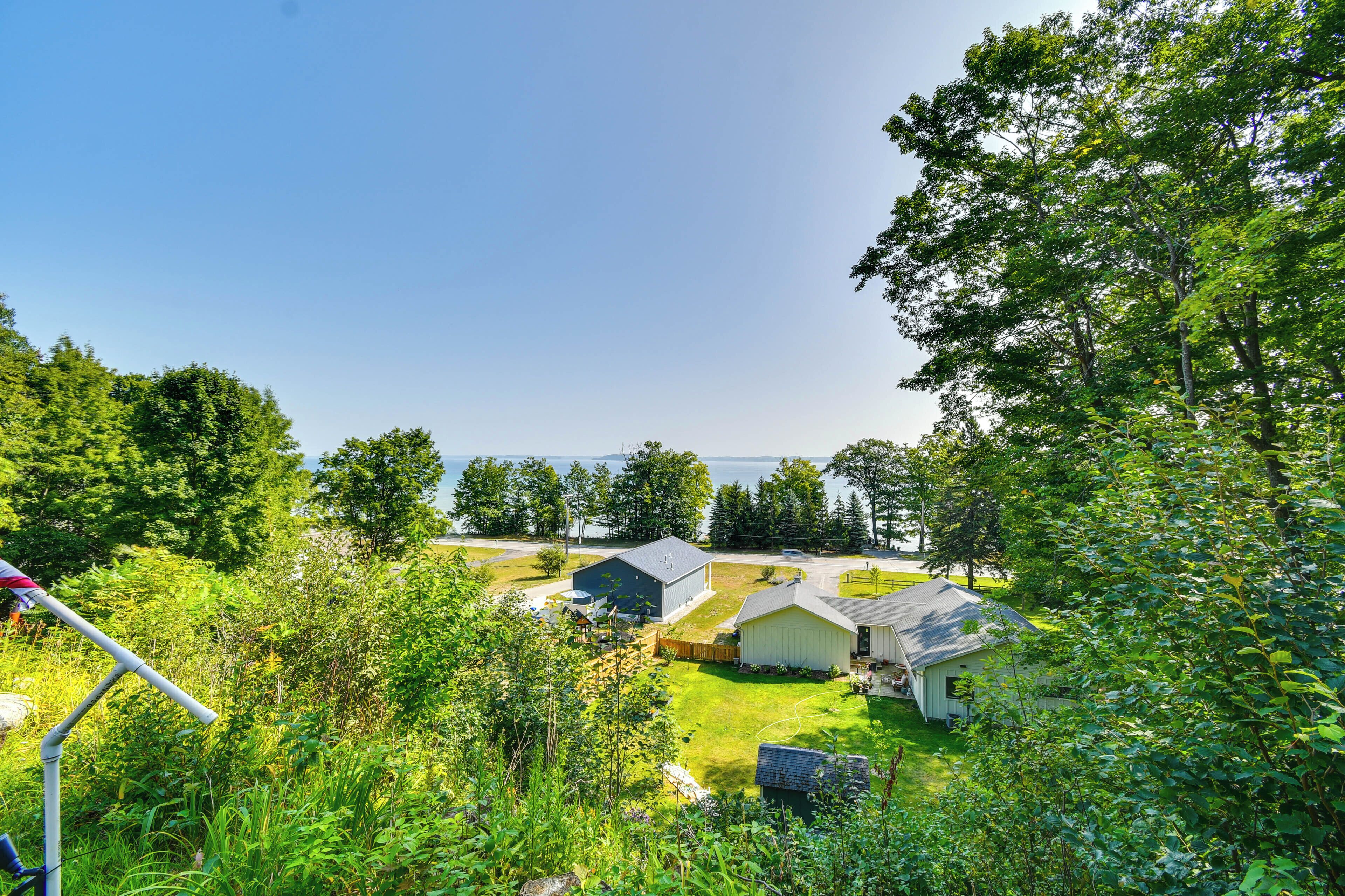 A residential area with houses, a grassy yard, and a view of the water.